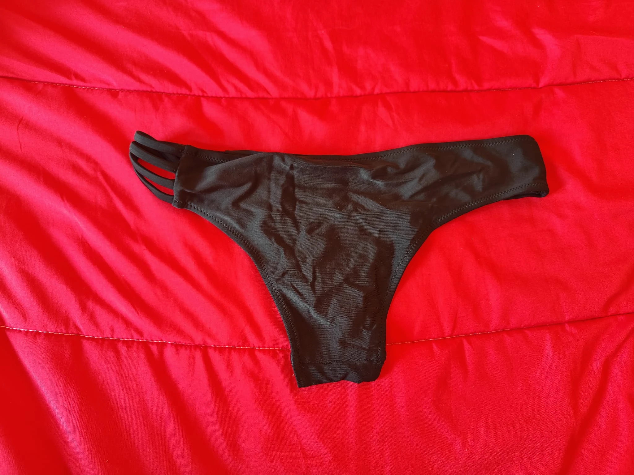 Black bikini-style briefs with a modern design and strap detail. – photo 2